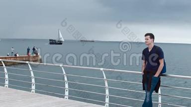 4一个<strong>手抄</strong>手站在码头上。 在背景上可以看到瓦夫切特和一艘船